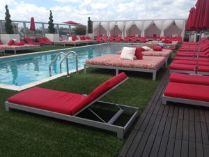 rooftop lounge area with pool artificial turf red lounge chairs