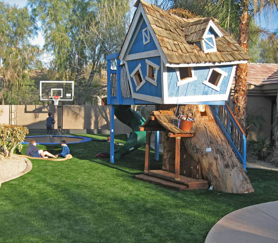 backyard with artificial turf children's blue tree house trampoline with basketball goal