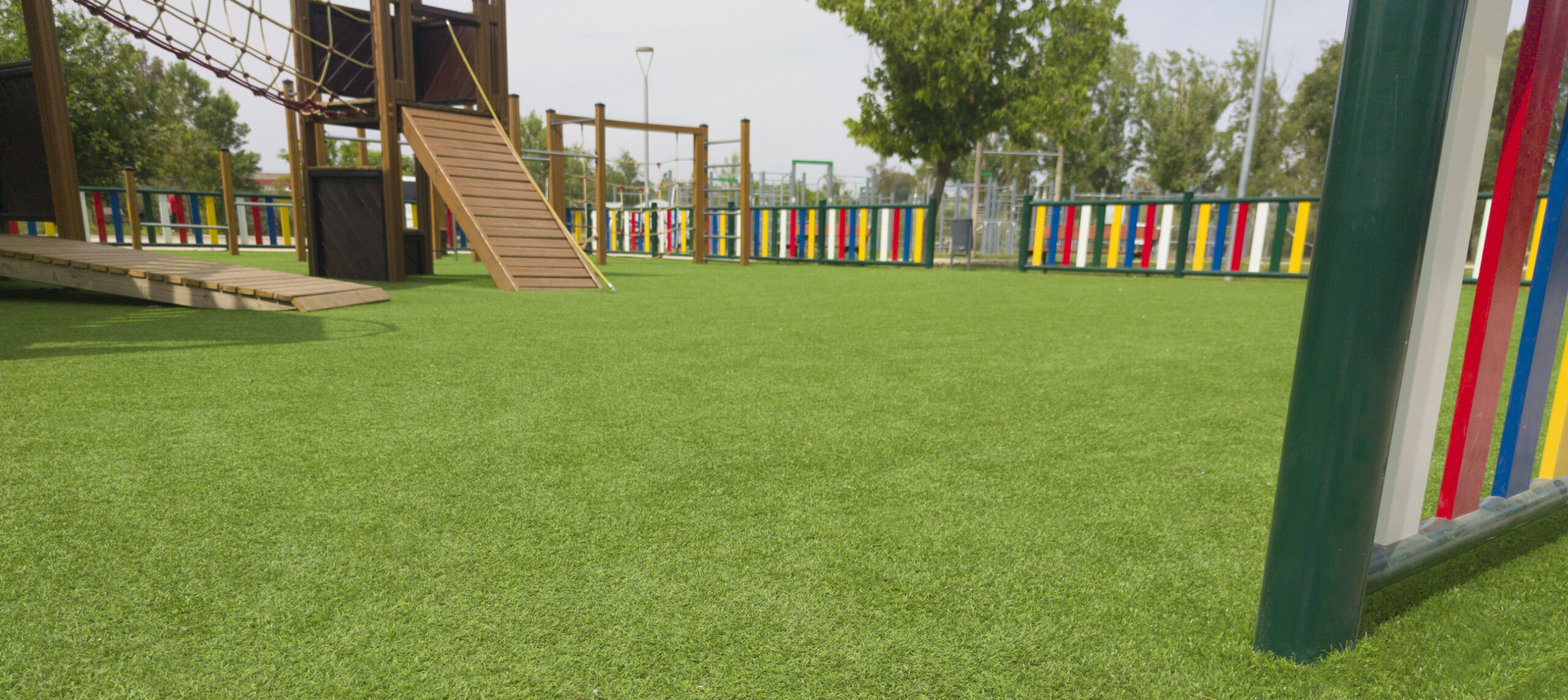 Artificial green grass at a colorful playground for creative-uses-for-artificial-turf blog.